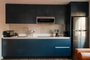 a kitchen with blue cabinets and a refrigerator at Casa Serenos in Mexico City