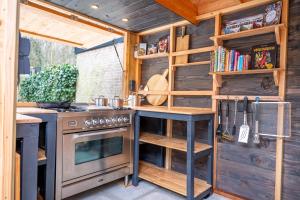 a kitchen in a tiny house with a stove at Kahakai Beach House - Unique Outdoor Kitchen - next to local lake and 15 min. the from beach in Noordwijkerhout