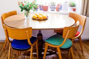 a dining room table with four chairs and a bowl of oranges at Przystanek w kolorach świata in Jelenia Góra