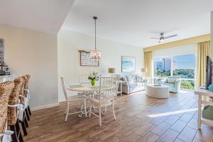 a dining room and living room with a table and chairs at Luau II 6429 in Destin