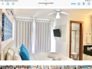 a living room with a bed and a ceiling fan at Casa Luna in Porto Seguro
