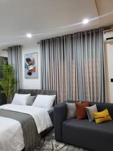 a bedroom with a bed and a couch at Stylish Modern Studio Apartment Banana Island Ikoyi in Lagos +29 photos