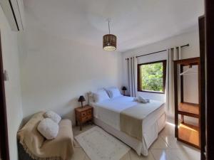 特蘭科索的住宿－Casa da Dilma Trancoso，卧室配有床、椅子和窗户。