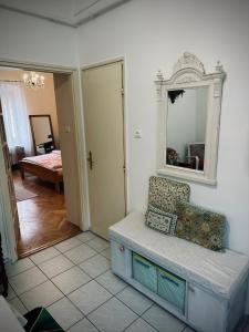 Cette chambre comprend un miroir et un banc. dans l'établissement Tabán Apartman, à Pécs