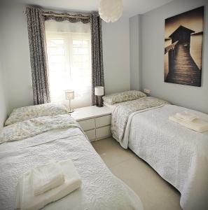 een slaapkamer met 2 bedden en een raam bij Sun Apartment Cristimar (3 bedrooms) in Los Cristianos