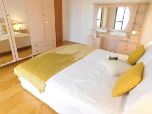 House Palm Tree في Žrnovnica: غرفة نوم بسرير ابيض كبير مع بطانيه صفراء