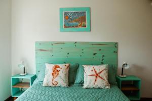 - une chambre avec un lit avec une tête de lit bleue et 2 tables dans l'établissement Agua de Mar I, à Mar de Cobo