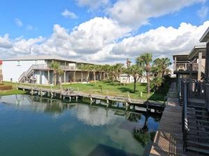 una casa con un muelle junto a un cuerpo de agua en Cast-A-Waves, en Port Aransas