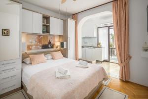 a bedroom with a large bed with two towels on it at Apartments Katana in Poreč