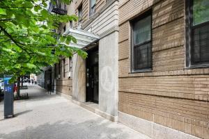 105 -5G Brand New Studio prime location Elevator في نيويورك: رصيف بجانب مبنى من الطوب مع نافذة