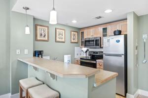a kitchen with a refrigerator and a counter top at Pilot House 412 in Destin