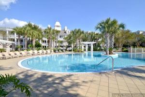 a large swimming pool with palm trees and a building at Pilot House 412 in Destin