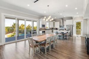 a kitchen and dining room with a table and chairs at Contemporary Waves by Brightwild-Huge Pool, Dock in Stock Island