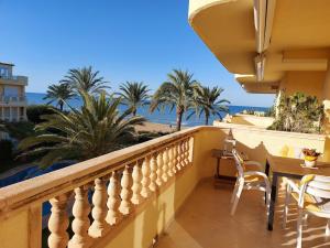 einen Balkon mit Tisch und Stühlen sowie Strand in der Unterkunft Estupendo apartamento en primera línea de playa y con vistas al mar in Denia