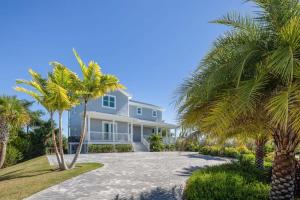 a house with palm trees in front of it at Contemporary Waves by Brightwild-Huge Pool, Dock in Stock Island