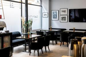 a restaurant with tables and chairs and a large window at Gardette Park Hotel in Paris