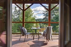 a screened in porch with a table and chairs at Front RIVER private BEACH 2 HOT TUBS 15 p SAUNA in Labelle
