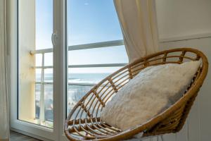 einem Korbsessel vor einem Fenster in der Unterkunft Atlantic Selection - La Centrale avec vue Océan in Soorts-Hossegor
