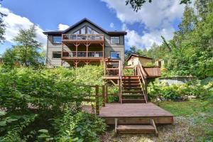 a house with a staircase leading up to it at Front RIVER private BEACH 2 HOT TUBS 15 p SAUNA in Labelle