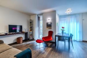 a living room with a table and a red chair at Luxury apartment - Free Parking - Duomo-Navigli in Milan