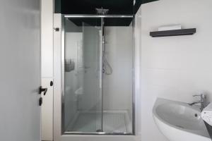 La salle de bains est pourvue d'une douche en verre et d'un lavabo. dans l'établissement Loft 36 by Omen Hospitality, à Rome
