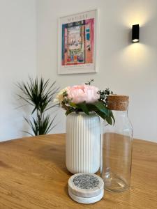 un vaso con dei fiori, seduto su un tavolo. di Exklusive Ferienwohnung im Stadtzentrum - 24h Check-in a Kiel