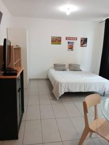 1 dormitorio con 1 cama, TV y silla en T3 Vieux Port Opéra en Marsella