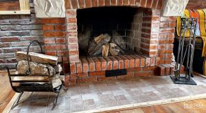 a brick fireplace with a pile of wood in it at O!Bora in Neple