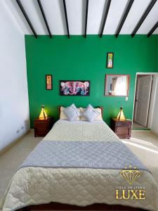 um quarto com uma parede verde e uma cama em HOTEL LEYVA LUXE em Villa de Leyva