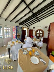 uma sala de jantar com mesas e cadeiras brancas em HOTEL LEYVA LUXE em Villa de Leyva