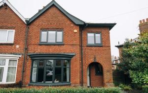 a red brick house with a large window at Regent's Retreat - Stunning home in Middlesbrough in Middlesbrough