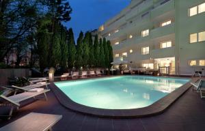 a large swimming pool in front of a building at Astoria Suite Hotel in Rimini