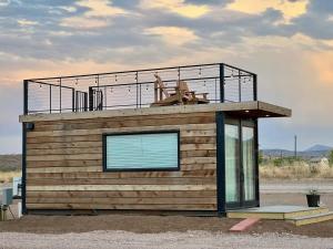 a small cabin with a balcony on top of it at New The Buffalo-Shipping Container in Alpine in Alpine