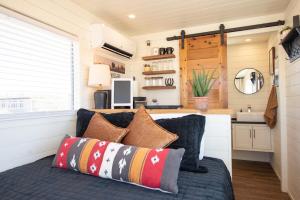 ein Zimmer mit einem Sofa mit Kissen und einer Küche in der Unterkunft New The Buffalo-Shipping Container in Alpine in Alpine