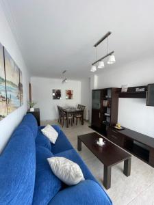 um sofá azul numa sala de estar com uma mesa em Apartamento Hío Aldán - Cangas em Vilariño