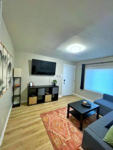 a living room with a blue couch and a tv at *NEW* The Cozy Haven, 5 minutes to ATL airport in Atlanta