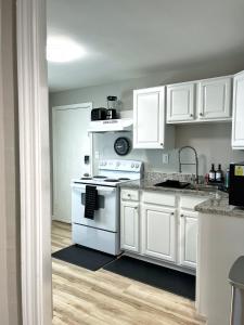 a kitchen with white cabinets and a white stove at *NEW* The Cozy Haven, 5 minutes to ATL airport in Atlanta