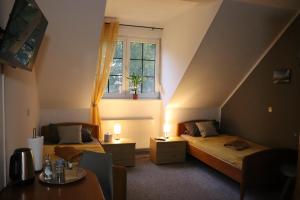 Zimmer im Dachgeschoss mit 2 Betten und einem Fenster in der Unterkunft Pension Lausitzer Seenland in Elsterheide