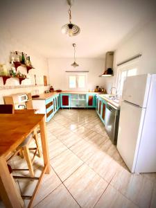 a kitchen with a white refrigerator and a wooden floor at Casa de Estrella in Costitx