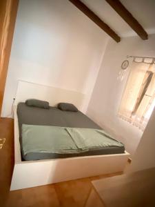 a bed in a white room with a window at Casa de Estrella in Costitx