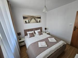 1 dormitorio con 1 cama y una pintura en la pared en Apartament na Orlej w Zamościu, en Zamość
