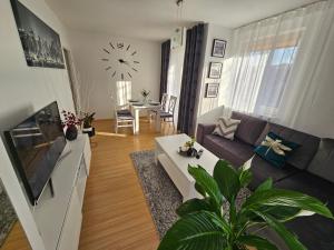 sala de estar con sofá y reloj en la pared en Apartament na Orlej w Zamościu, en Zamość