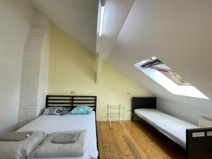 a attic bedroom with two beds and a skylight at Schöpfwerk Hostel in Vienna