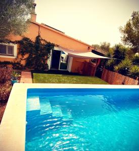a blue swimming pool in front of a house at Casa de Estrella in Costitx