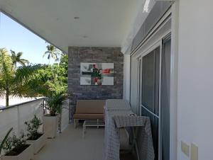 einen Balkon mit einem Tisch und einer Bank auf einem Gebäude in der Unterkunft Appartement 1 CH centre Las Terrenas 100 m2 piscine et parking in Las Terrenas