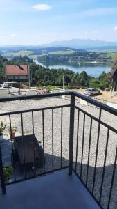 a balcony with a view of a body of water at Widokowy Zakątek in Czorsztyn +4 photos