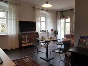 uma sala de estar com uma mesa e uma televisão em Ehemalige Klosterschmiede -Wirtschaftswunder- em Ochsenhausen