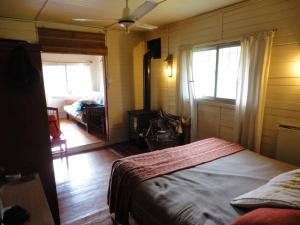 a bedroom with a bed and a living room at Cabaña hippie chic en isla del Delta (Rompani) in Tigre