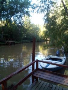 a small boat tied to a dock on a river at Cabaña hippie chic en isla del Delta (Rompani) in Tigre +4 photos