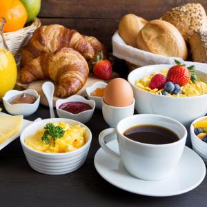 a breakfast table with cups of coffee and breakfast foods at Holiday Inn Leeds-Wakefield M1 Jct40, an IHG Hotel in Wakefield
